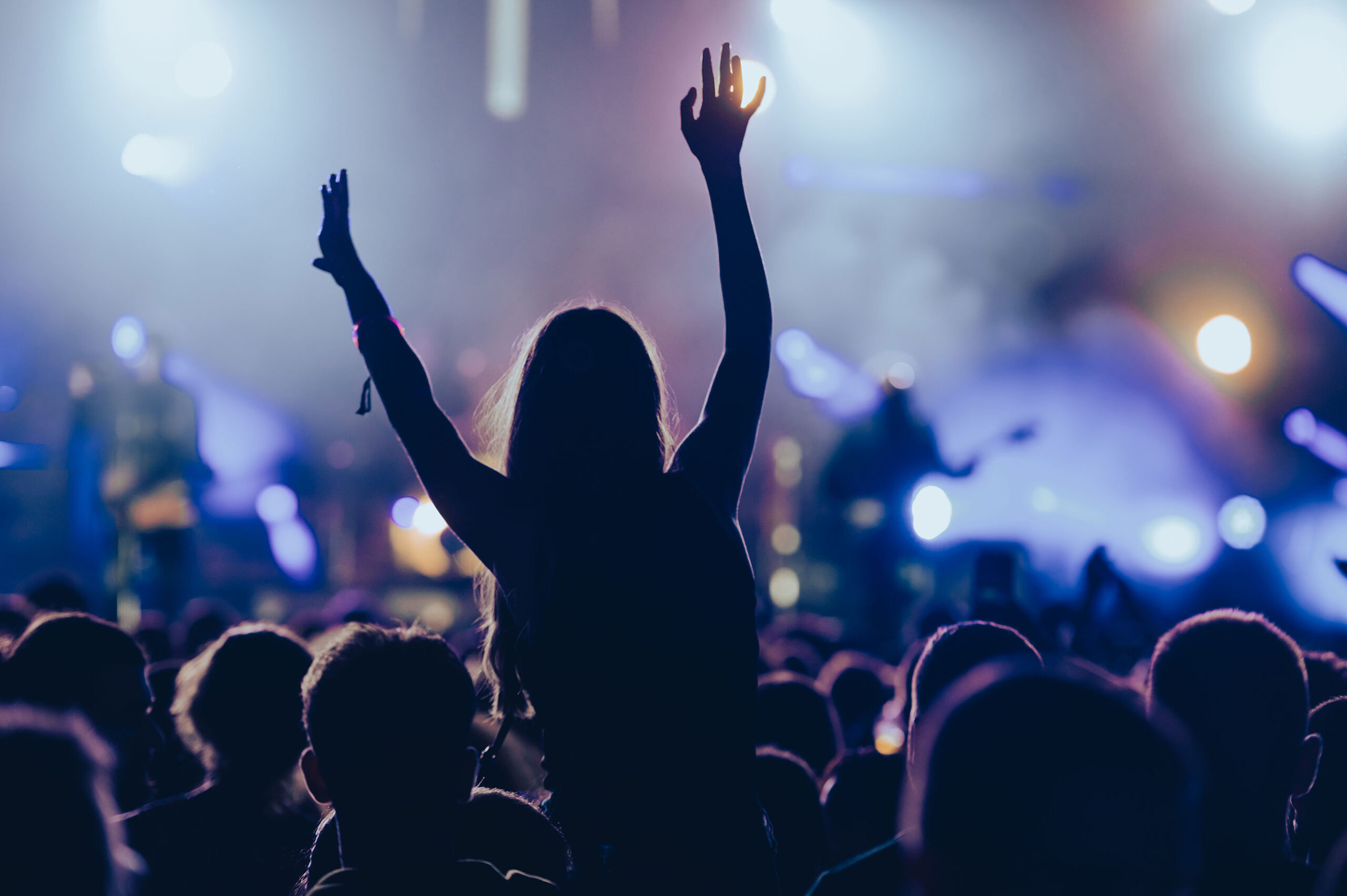 A crowd watches a band perform on stage.